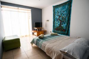 a bedroom with a bed and a rug on the wall at Sueños de Chicama in Puerto Chicama
