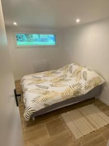a small bed in a room with a window at Appartement 60m2 6 voyageurs in Moisson