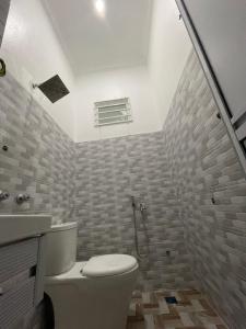 uma casa de banho com um WC e um lavatório em Dhuha & Dharyl's Staycation em Kota Bharu
