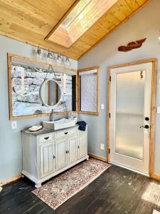 a bathroom with a sink and a mirror at The Salish Sunset Cabin in Pender Island