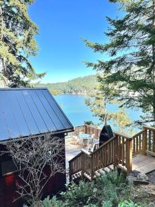 a large wooden deck with a view of a lake at The Salish Sunset Cabin in Pender Island