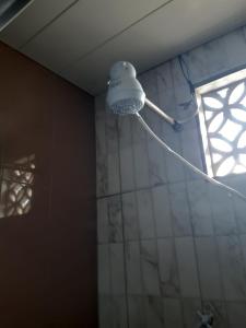Pousada do Joaquimxdarc في ناتال: حمام مع دش مع ضوء على الحائط