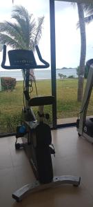 a gym with a treadmill and a view of the ocean at Baan Tasha in Laem Sor
