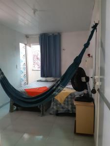 a hammock in a room with a bed at Pousada do Joaquimxdarc in Natal