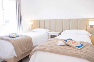 a hotel room with two beds with towels on them at Villa privada en Corralejo in Corralejo