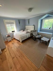 1 dormitorio con 1 cama, 1 silla y 2 ventanas en Riverfront Paradise Villa, en Hveragerði