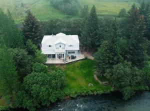 una vista aérea de una casa blanca con un río en Riverfront Paradise Villa, en Hveragerði