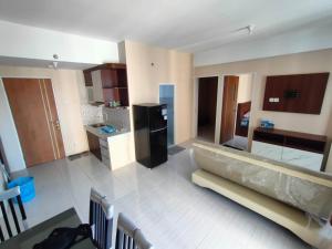uma grande cozinha com um sofá no meio de um quarto em Made Residence and Apartment em Surabaya
