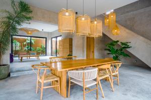 - une salle à manger avec une table et des chaises en bois dans l'établissement Villa Noi - Sumptuous 4 bedroom private luxury villa in Berawa, Canggu, à Canggu