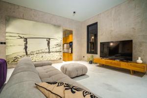 Il comprend un salon doté d'un canapé et d'une télévision à écran plat. dans l'établissement Villa Noi - Sumptuous 4 bedroom private luxury villa in Berawa, Canggu, à Canggu