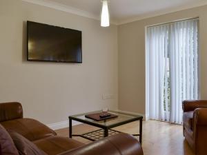 a living room with a couch and a table and a tv at Hollies Cottage 3 - Ukc4522 in Martock