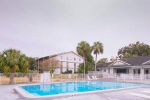 a large swimming pool in front of a house at Modern Boho Condo with a Royal Touch -KING BED in Gainesville