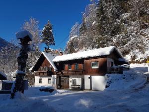 una casa está cubierta de nieve con nieve en Charming small apartment with free parking, en Feld am See