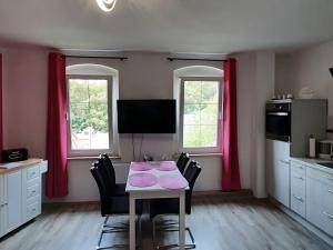 uma cozinha com uma mesa com cadeiras e cortinas cor-de-rosa em Property in Burgk em Burgk