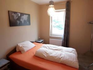a bedroom with an orange bed and a window at Property in Burgk in Burgk