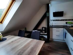 an attic kitchen with a wooden table and chairs at Property in Burgk in Burgk