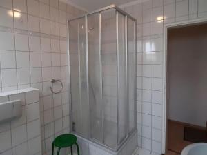 La salle de bains est pourvue d'une douche avec un tabouret vert. dans l'établissement Property in Wildemann, à Wildemann