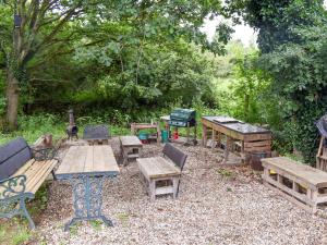 a group of picnic tables and benches in a yard at Shepherds Hut 1 At Laddingford - Uk32531 in Yalding