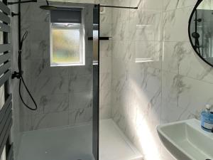een badkamer met een douche en een wastafel bij Tregarthen Cottage in Perranuthnoe