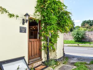 um edifício com uma porta e hera à volta em Canons Hall Cottage em Wingham