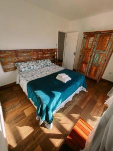 1 dormitorio con 1 cama y suelo de madera en Casa Arraial do Cabo Beachfront en Arraial do Cabo