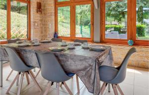ein Esszimmer mit einem Tisch mit Stühlen und Fenstern in der Unterkunft Nice Home In Casseneuil With Outdoor Swimming Pool in Casseneuil