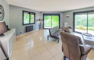 ein Wohnzimmer mit Stühlen, einem Tisch und Fenstern in der Unterkunft Nice Home In Casseneuil With Outdoor Swimming Pool in Casseneuil