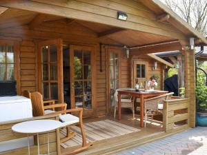 a wooden cabin with a table and chairs on a deck at Oakwell Lodge in Rainham