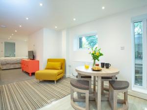 uma sala de estar com uma mesa e uma cadeira amarela em Croftys Celder - Uk35181 em Pool