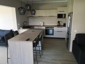 a kitchen with a wooden table and some chairs at Moana Beach Apartment in Noumea