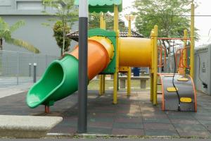 a playground with a slide in a park at Miro Resthouse by the Pool in Kajang