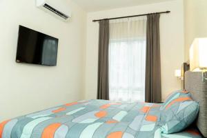 1 dormitorio con 1 cama y TV de pantalla plana en Miro Resthouse by the Pool en Kajang
