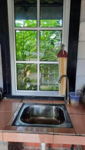 a kitchen sink in front of a window at GekQ Inn Langkawi B in Pantai Cenang