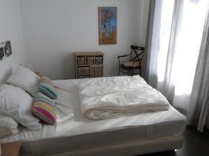 - un lit avec des draps et des oreillers blancs dans une chambre dans l'établissement Maison La Tranche-sur-Mer, 4 pièces, 6 personnes - FR-1-194-36, à La Tranche-sur-Mer