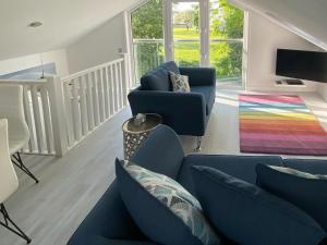 sala de estar con sofá azul y alfombra colorida en Rainbows End, en Saint Lawrence