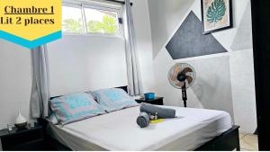 niewielka sypialnia z łóżkiem i wentylatorem w obiekcie VHouse 2 w mieście Bora Bora