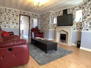 a living room with a couch and a tv and a fireplace at Oakland in Fleetwood