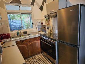 uma cozinha com um frigorífico de aço inoxidável e um lavatório em VHouse 2 em Bora Bora