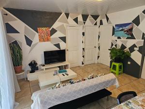 salon z kanapą i telewizorem w obiekcie VHouse 2 w mieście Bora Bora