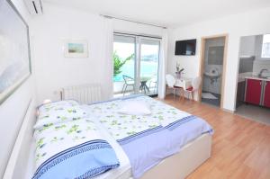 a bedroom with a large bed and a dining room at Apartments Zorka Leko in Omiš