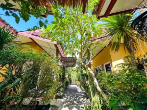 una pasarela que conduce a una casa con árboles y plantas en Lanta Baan Nok Resort en Ko Lanta