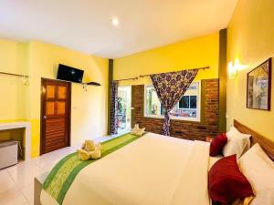 a bedroom with a large bed with two stuffed animals on it at Lanta Baan Nok Resort in Ko Lanta