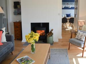 a living room with a fireplace and a vase of flowers at Beach Haven in Sheringham