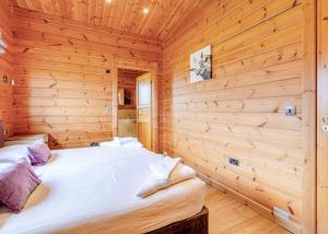 ウィズンシーにあるFairview Lodgesの木製の壁に大きなベッドが備わるベッドルーム1室