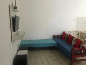 a living room with a blue couch and a tv at Casa de Praia Mongaguá in Mongaguá