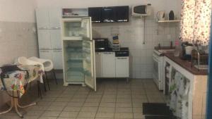 a kitchen with white appliances and a tiled floor at Casa de Praia Mongaguá in Mongaguá