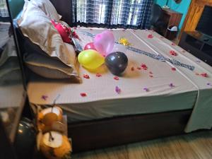 a bed with balloons and flowers on top of it at The Surf Access Guest House in Arugam Bay