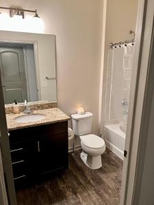 a bathroom with a toilet and a sink and a tub at Excellent Location- Perfect Shared Homestay! in Yaphank