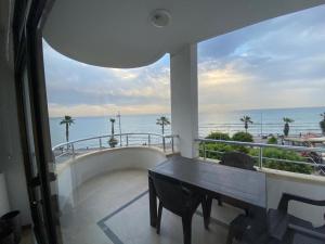 een balkon met een tafel en uitzicht op de oceaan bij Luxury apartment with sea view in Mezitli