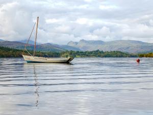 un barco sentado en medio de un cuerpo de agua en Lake View, en Bowness-on-Windermere